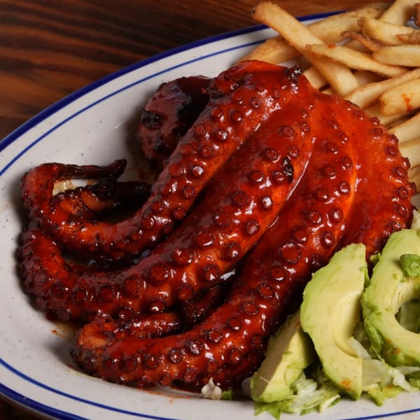 El Mezcal's grilled octopus in red sauce with avocado slices and french fries.