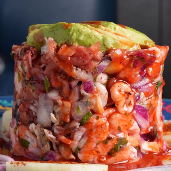 El Mezcal's vibrant ceviche tower with shrimp, red onion, and avocado, drizzled with red sauce.