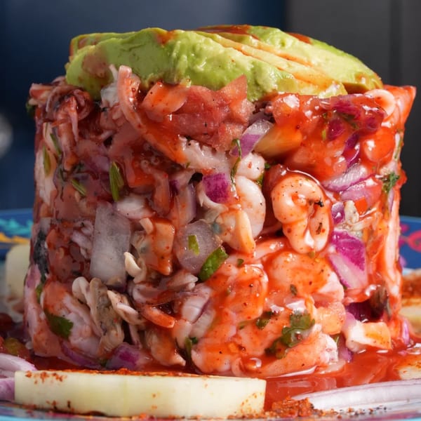 El Mezcal's vibrant ceviche tower with shrimp, octopus, red onion, and avocado, drizzled with red sauce.