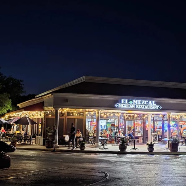 El Mezcal Mexican Restaurant at night, with string lights illuminating the outdoor patio and entrance.